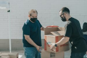 Two men moving food boxes.